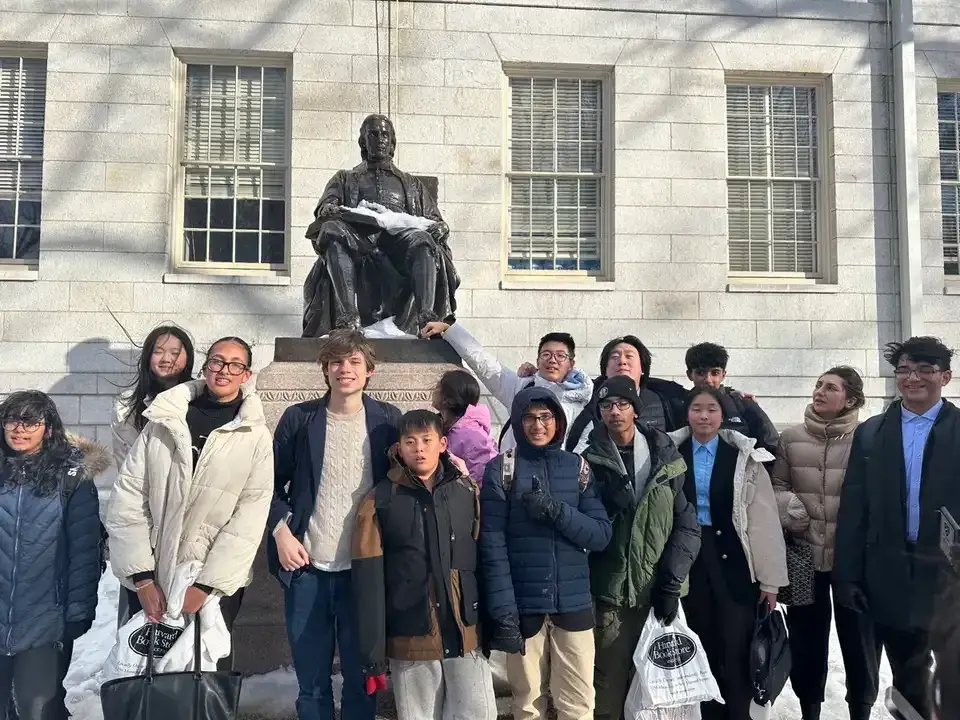 A large group of WSC Academy students celebrating together on a university campus visit